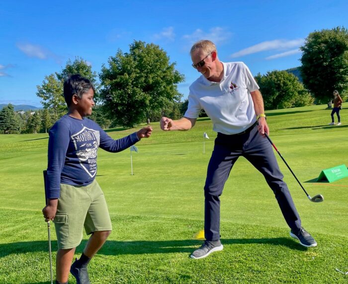 Coach Wayne Allen fist bumping First Tee participant